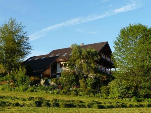 a large house with a garden in front of it at Haus am See in Illmensee
