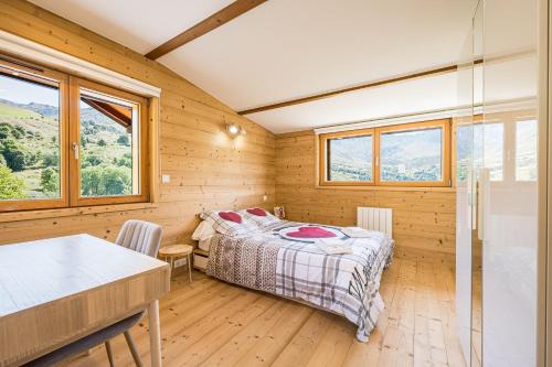 a bedroom with a bed in a wooden room with windows at La scierie de la grande ourse in Albiez-Montrond
