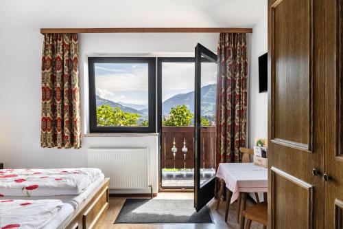 a bedroom with two beds and a window at Pension Heidelberg in Hopfgarten im Brixental