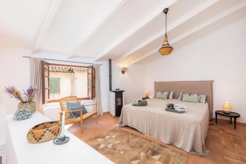a white bedroom with a bed and a window at Casa Max in Artá