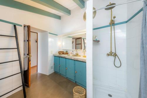 a bathroom with blue cabinets and a shower at Casa Max in Artá