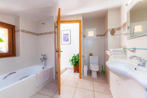 a bathroom with a tub and a sink and a toilet at Can Murons in Fornalutx