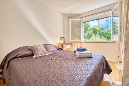 a bedroom with a bed and a window at L'appartement d'Olympe in Périgueux