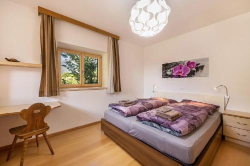 a bedroom with a bed and a desk and a chair at Ferienwohnung Lafreid Algund in Lagundo