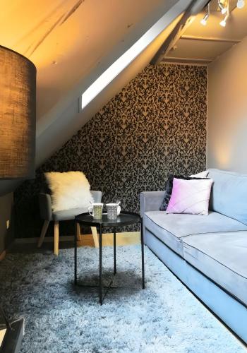 a living room with a couch and a table at Escale Glamour et Chic in Niederbronn-les-Bains