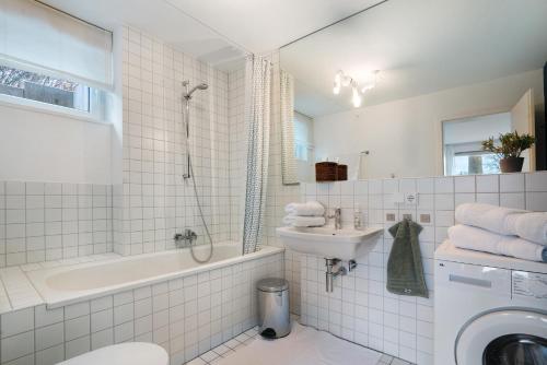 a bathroom with a sink and a toilet and a shower at Modernes Apartment Ammersee in Windach