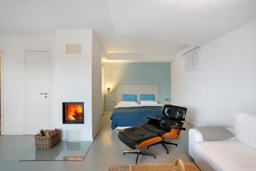 a bedroom with a bed and a black leather chair at Modernes Apartment Ammersee in Windach