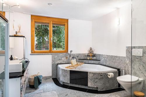 a bathroom with a tub and a toilet and a sink at Ferienwohnung Nearby in Thüringen