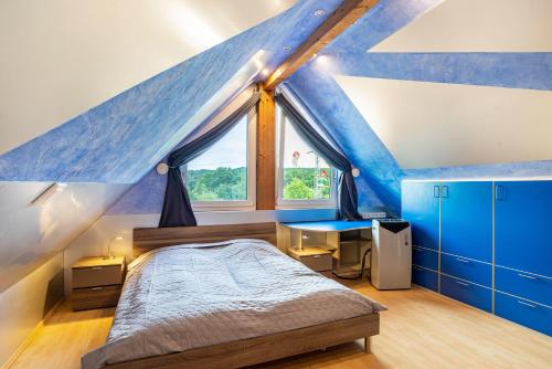 a bedroom with a blue roof with a bed and a desk at bei den Holzäppeln in Völkersweiler