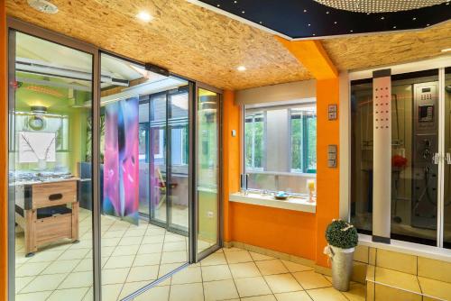 an office lobby with orange walls and windows at bei den Holzäppeln in Völkersweiler