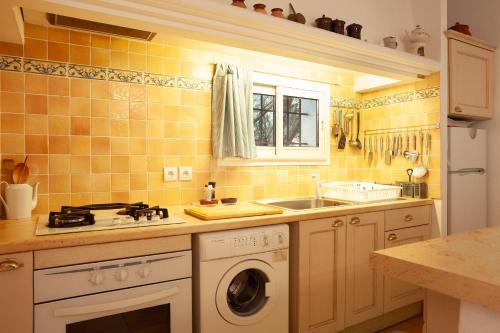 a kitchen with a sink and a washing machine at Les Cigales in Ceyreste