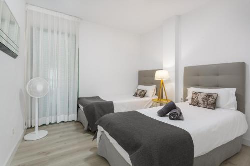 a hotel room with two beds and a fan at Espectacular Y Amplio Las Américas in Playa de las Americas