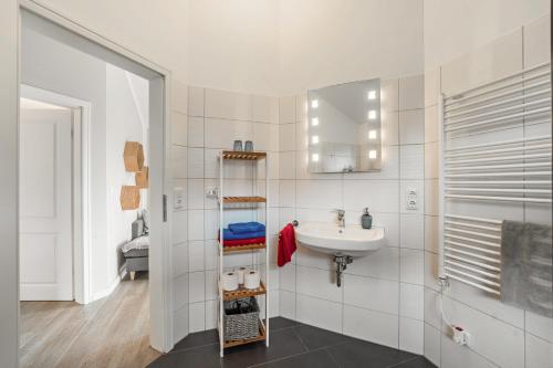 a white bathroom with a sink and a mirror at Nordlicht in Fehmarn