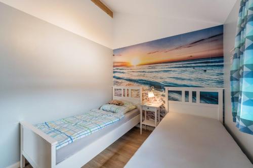 a bedroom with a bed and a painting on the wall at Nordlicht in Fehmarn