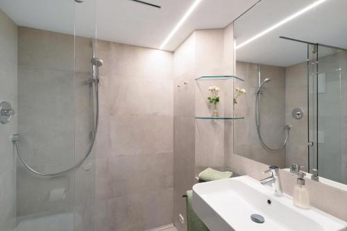 a bathroom with a shower and a sink and a mirror at Ansitz Baumannhof Apt 1818 in Falzes