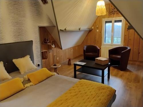 a bedroom with a bed and a table and chairs at Chambres D'hôtes in Videcosville