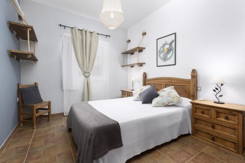 a bedroom with a large bed and a chair at Casa Guerepe in La Pared