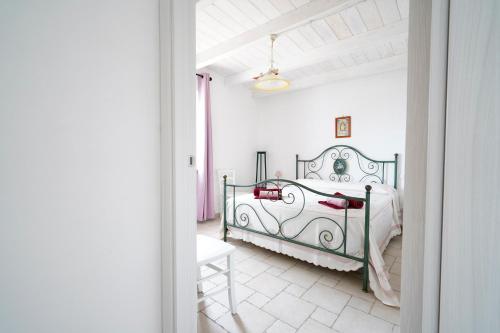 a bedroom with a green bed in a white room at Casina delle Rose - Scirocco in Polignano a Mare