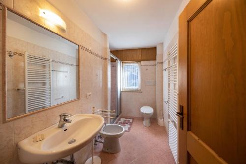 a bathroom with a sink and a toilet at Appartamento Primavera 4 in Moena
