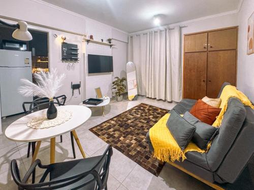 a living room with a couch and a table at Studio 43 - Central Coração de Franca in Franca