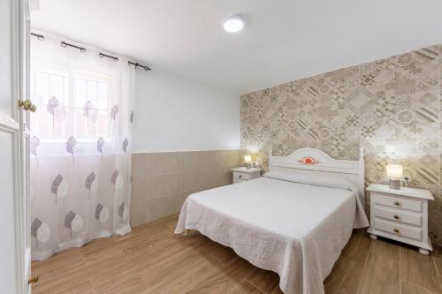 a bedroom with a white bed and a window at Noria 2 in Níjar