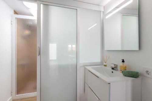 a white bathroom with a sink and a shower at La Gomera in La Victoria de Acentejo