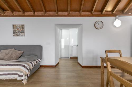 a bedroom with a bed and a table and a clock at La Gomera in La Victoria de Acentejo