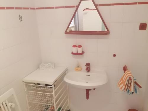 a white bathroom with a sink and a mirror at Ferienwohnung Rösner in Herzhausen
