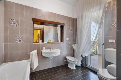 a bathroom with a sink and a tub and a toilet at Villa Cristina - vista mare in Boissano