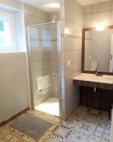a bathroom with a shower with a sink and a mirror at Maison quartier Porzic vue Mer in Crozon