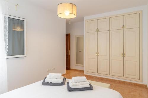 a bedroom with a white bed and a closet at El Barquillo in La Santa