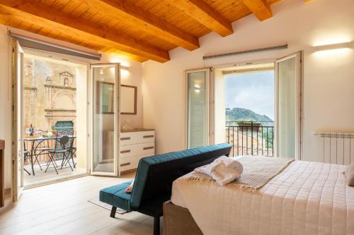 a bedroom with a bed and a balcony at Vico degli Orti in Mistretta