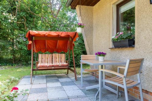 a patio with a table and chairs and a window at Ferienhaus Krohse in Potsdam