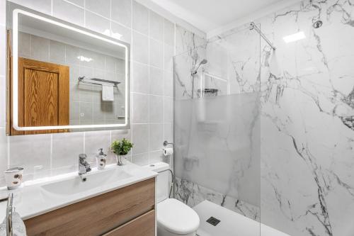 a white bathroom with a sink and a toilet at Casa Brisas De Candelaria in Candelaria