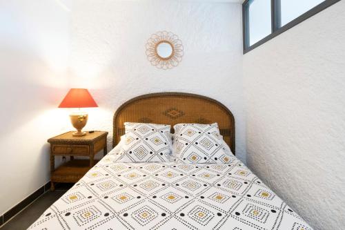 a bedroom with a bed and a table with a lamp at Entre Terre et Mer in Ciboure