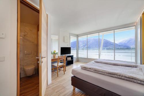 a bedroom with a bed and a large window at Villa Alvarium Eins in Schenna