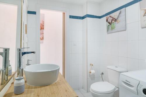 a white bathroom with a tub and a toilet at Vistamar in Puerto del Carmen