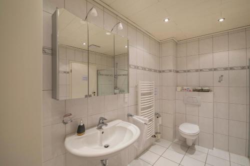 a white bathroom with a sink and a toilet at mit Wintergarten nah Moviepark in Bottrop
