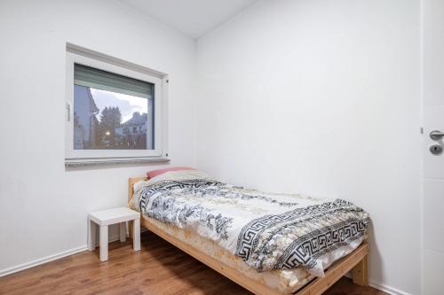 a bed in a white room with a window at Cozy Ground Floor Apartment in Bremen