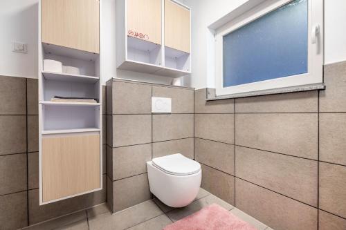 a bathroom with a toilet and a window at Cozy Ground Floor Apartment in Bremen