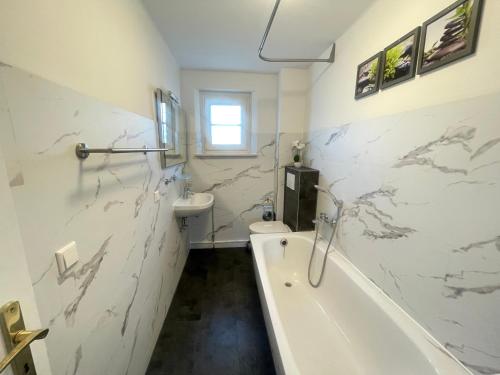 a bathroom with a tub and a toilet and a sink at Ferienwohnungen Neuseenland in Rötha