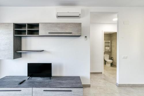 a kitchen with white walls and a tv on a counter at Giuliano Superior 2 para 4 personas in Empuriabrava