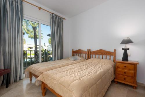 a bedroom with a bed and a large window at Apartamento de lujo a 30m playa in Estepona