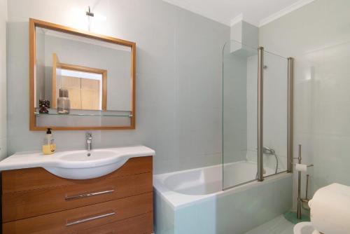 a bathroom with a sink and a shower and a mirror at Sunset House Algarve in Faro