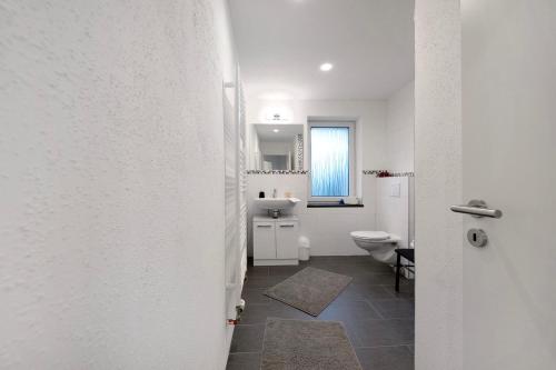 a white bathroom with a toilet and a sink at Fewo Weber in Sankt Ingbert