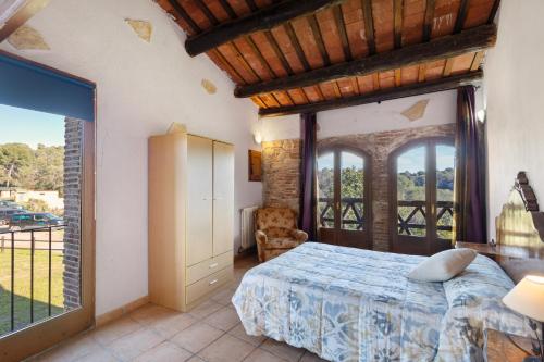 a bedroom with a bed and a large window at Can Llevorer in Caldes de Montbui