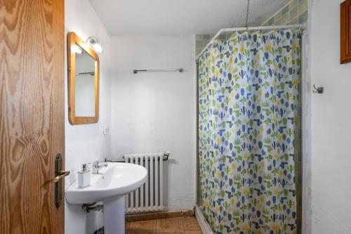 a bathroom with a sink and a shower curtain at Can Llevorer in Caldes de Montbui