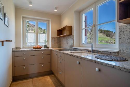 a kitchen with a sink and two windows at Alber Ferienwohnung Mürri in Verano