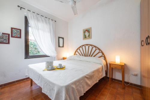a bedroom with a bed with a table and two candles at Casa Luisella in Costa Rei