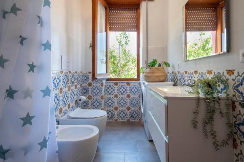 a bathroom with a toilet and a sink at Spacious home in Costa Rossa in Trinità d'Agultu e Vignola